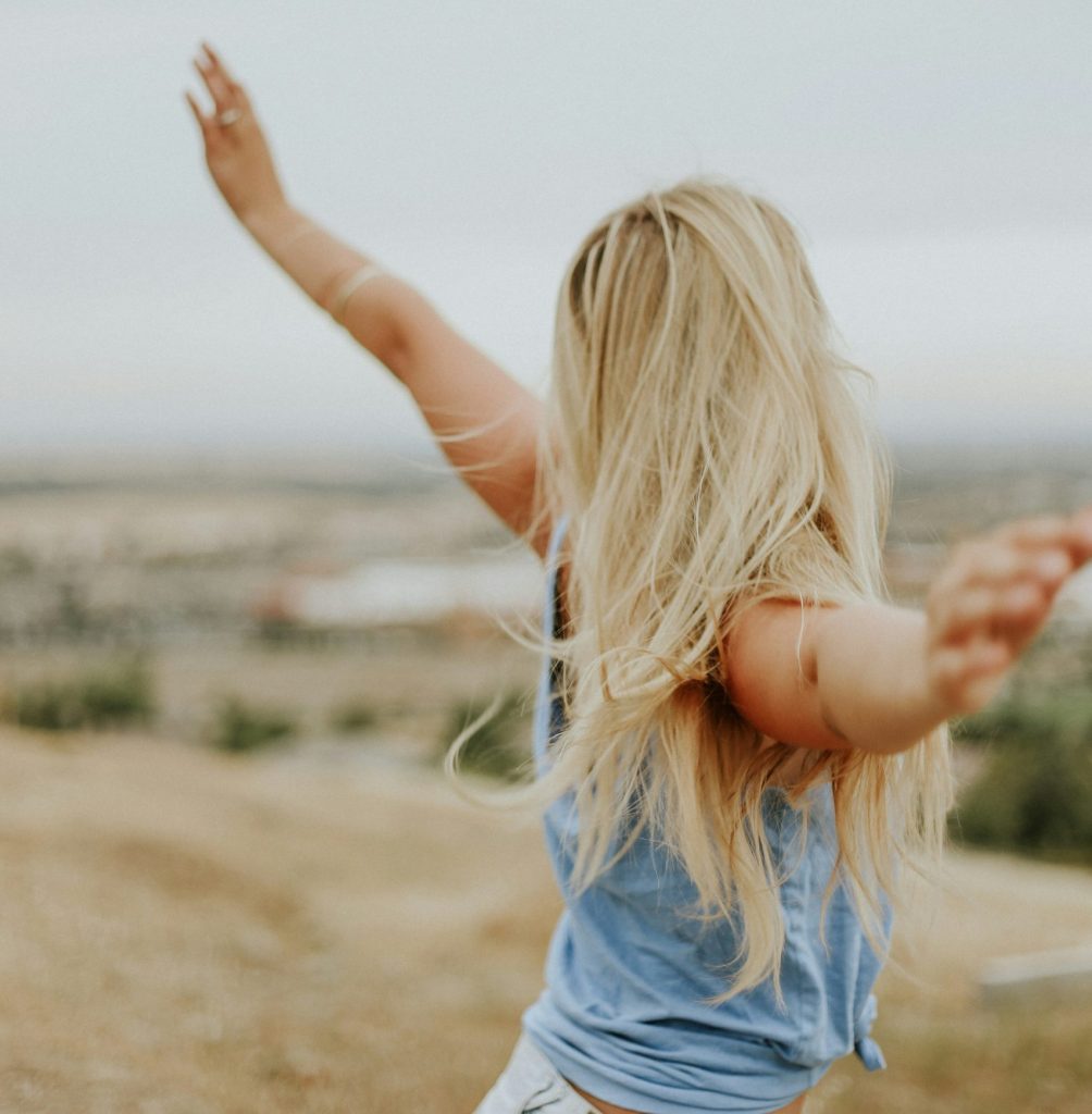 Blonde Lady with her hands up in the air enjoying the moment